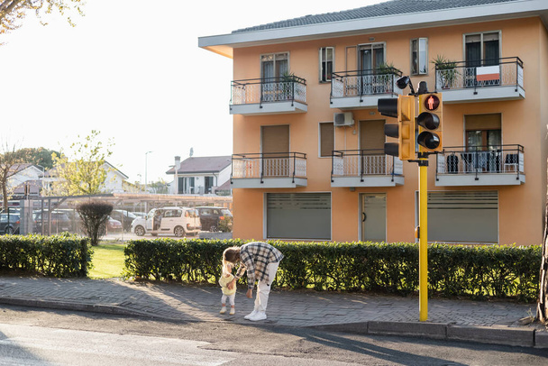 Jonge vader staat in de buurt van baby meisje en zebrapad op stedelijke straat in Treviso - Foto, afbeelding