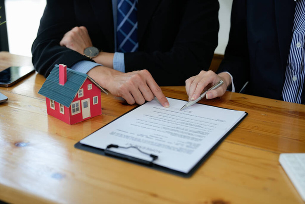 不動産業者は、住宅購入契約の条件について話し、顧客に契約を合法的にするために文書に署名するように依頼しました、住宅販売と住宅保険の概念 - 写真・画像