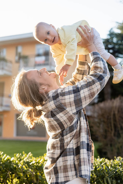 Homem positivo brincando com a filha bebê na rua urbana em Treviso - Foto, Imagem