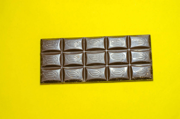 Dark chocolate on a yellow background - Fotografie, Obrázek
