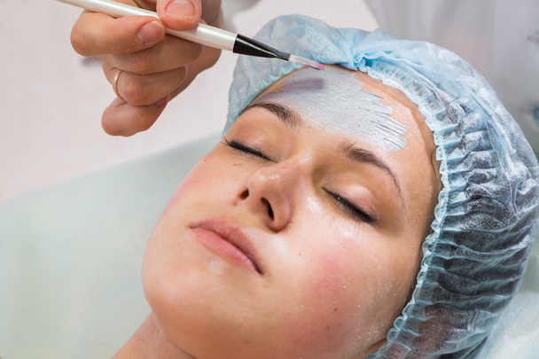 Terapeuta aplicando máscara facial a la mujer
 - Foto, imagen