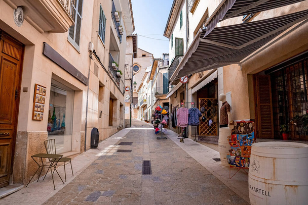 Mallorca, Spain. April 27, 2022. Various merchandise shops with awnings in alley. Buildings at residential district against clear sky. Shadow falling in town during summer. - Valokuva, kuva