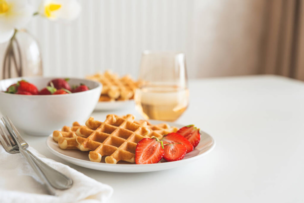 Belgian waffles with strawberry on white plate. Breakfast food concept. Copy space - Zdjęcie, obraz