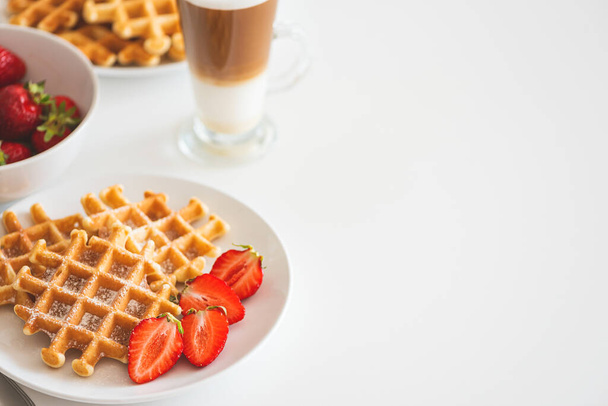 Belgian waffles with strawberry and coffee latte on white plate. Breakfast food concept. Copy space - Foto, imagen