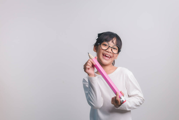 Muchacha joven emocionada sosteniendo grandes lápices en sus manos.Regreso a la escuela. - Foto, imagen