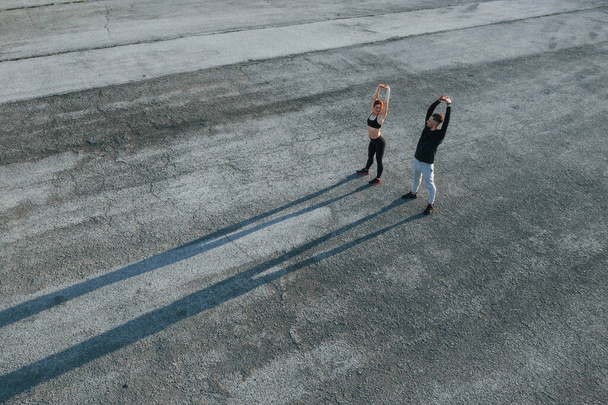 Top view of woman and man that have fitness day on the road at evening together. - Fotografie, Obrázek
