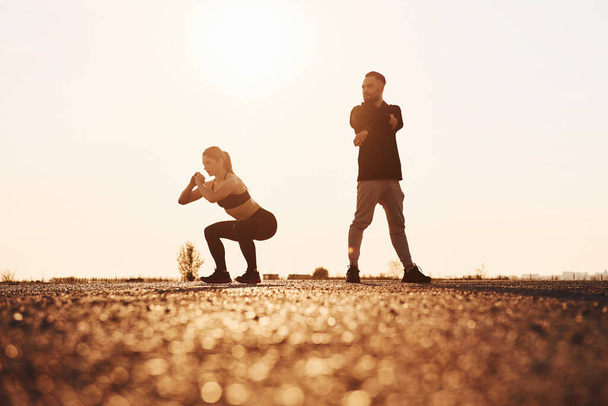 Woman and man have fitness day on the road at evening together. - Foto, Imagem