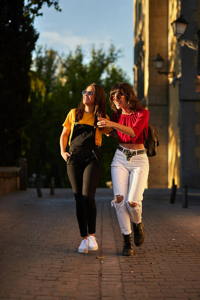 Two teenager girls walking down the street. - Photo, image