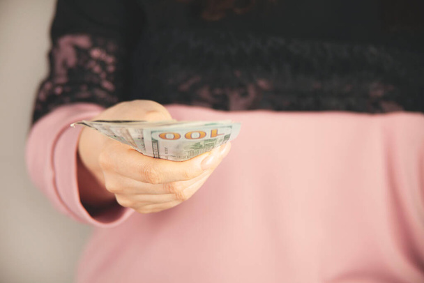 young woman hand money on gray background - Zdjęcie, obraz
