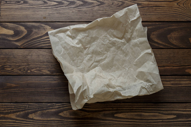 zmačkaný balicí papír na dřevěném stole - Fotografie, Obrázek