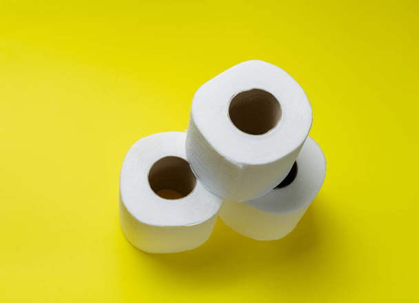 slide of toilet paper rolls on a yellow background. - Foto, imagen