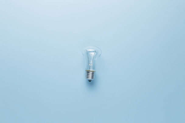 light bulb in hand on a blue background. - Valokuva, kuva