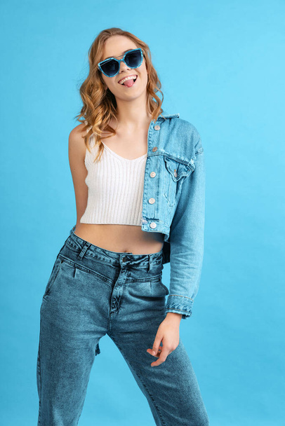 Cheerful young pretty girl in casual style outfit isolated on blue background. Concept of beauty, art, fashion, youth, spring collection - Foto, Bild