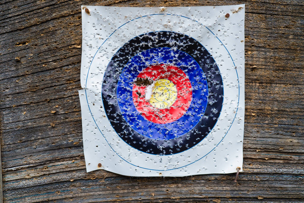 Bullseye in bow and arrow shooting range. Close-up of an archery shooting target paper with lots of holes. - Fotografie, Obrázek