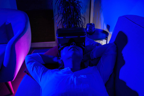 Relaxed woman in armchair with augmented reality glasses - Foto, Imagem