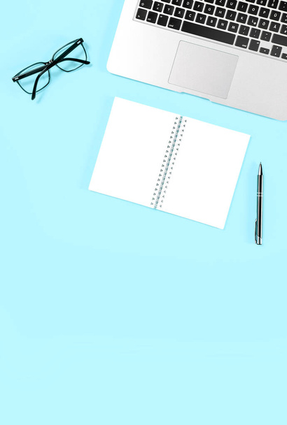 Office flat lay template. Laptop notebook pen on blue background - Foto, Bild