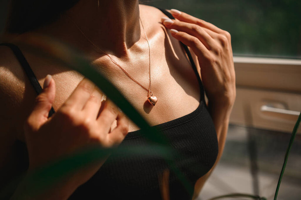 Beautiful neckline of a girl with a chain and a pendant in the form of a heart - Foto, Imagen