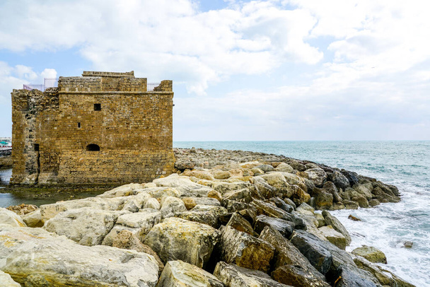 Kıbrıs 'taki Antik Paphos Kalesi ve Akdeniz arka planına karşı büyük taşlardan yapılmış bir rıhtım - Fotoğraf, Görsel