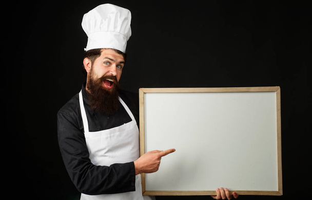 Chef showing empty menu sign board with copy space for text. Food service. Restaurant advertising. - Fotoğraf, Görsel