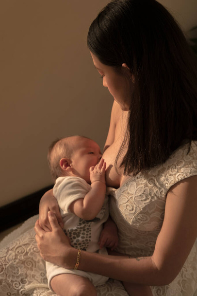 Latin mother lactating newborn baby, breastfeeding on the sun set - Foto, immagini