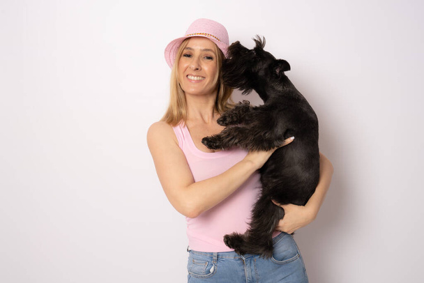 Cute young woman hugs her puppy schnauzer dog. Love between owner and dog. Isolated on white background. Studio portrait. - Φωτογραφία, εικόνα