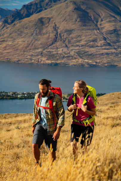 South Island Queenstown successful Caucasian adventure travel couple with backpacks resting on hike of Fjordland The Remarkables National Park Otago - Photo, Image