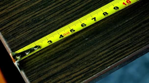 Close-up of a yellow metal measuring tape placed horizontally - Materiaali, video
