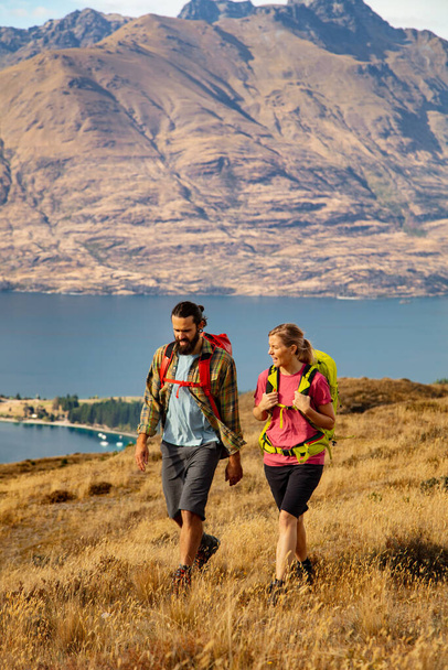 Travel Queenstown New Zealand young extreme Caucasian adventure male and female couple hiking with backpacks near Lake Wakatipu The Remarkables Otago - Photo, Image