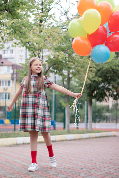 Teenage girl with colorful helium air balloons having fun outdoors. Tween Party. enjoying summer. - Fotó, kép