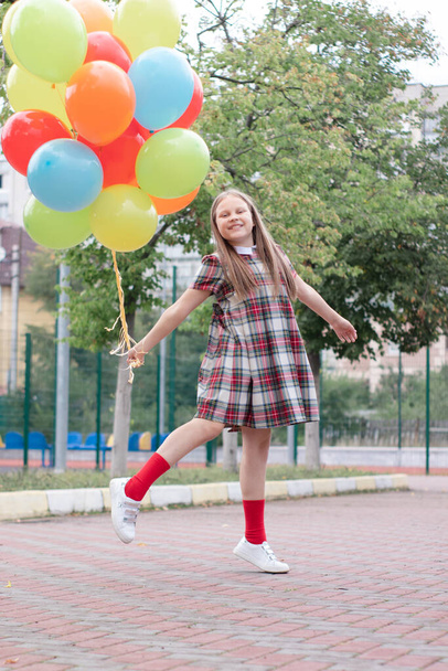 カラフルなヘリウム気球を持つ10代の女の子は屋外で楽しんでいます。パーティーの間だ。夏を楽しむ. - 写真・画像
