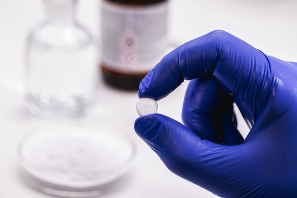 tabletas de ácido acetilsalicílico de mano farmacéutica, obtenidas por ácido salicílico y anhídrido acético, conocido como aspirina - Foto, imagen