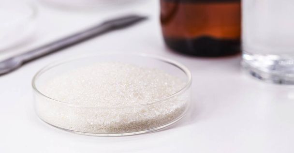 acetilszalicilsav kristályok petri-csészében, acetilszalicilsav vagy aszpirin tabletták gyártásához használt kémiai összetevő - Fotó, kép