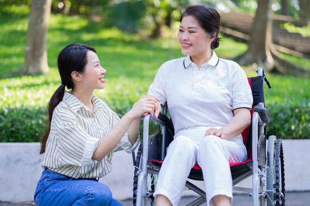Young Asian daughter taking care of her disabled mother - Photo, Image