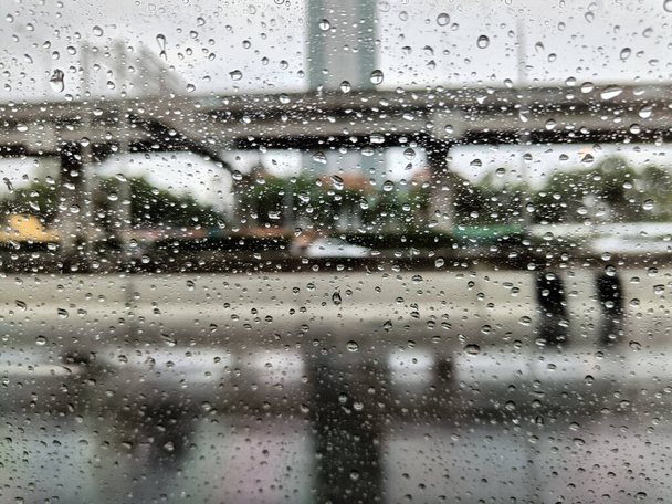 La pluie tombe sur la surface du verre de la fenêtre. Fond pluvieux - Photo, image