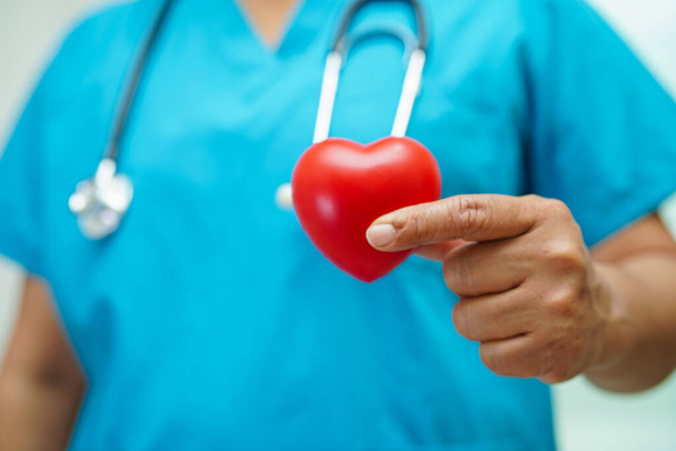 Azji kobieta lekarz gospodarstwa czerwone serce dla zdrowia w szpitalu. - Zdjęcie, obraz