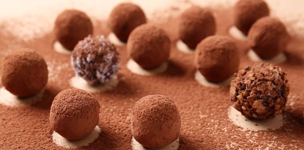 Tasty chocolate truffles and cacao powder on light background - Fotó, kép