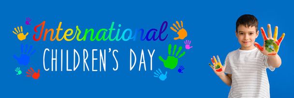 Cute little boy with hands in paint on blue background. International Children's Day - Foto, Imagem