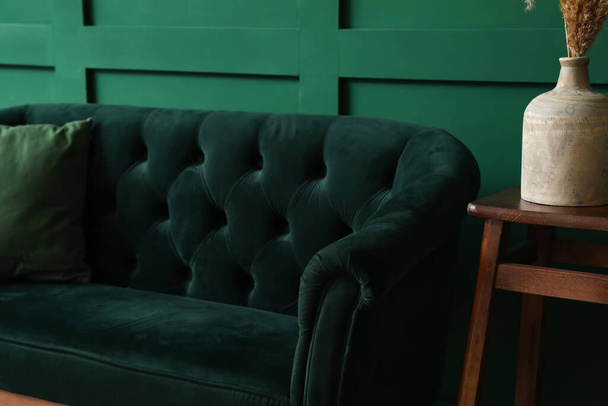 Stílusos kanapé közel zöld fal - Fotó, kép