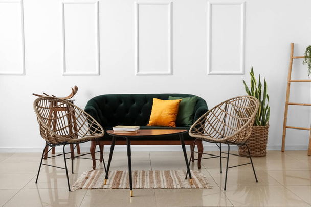 Stylish sofa and armchairs near light wall - Foto, imagen