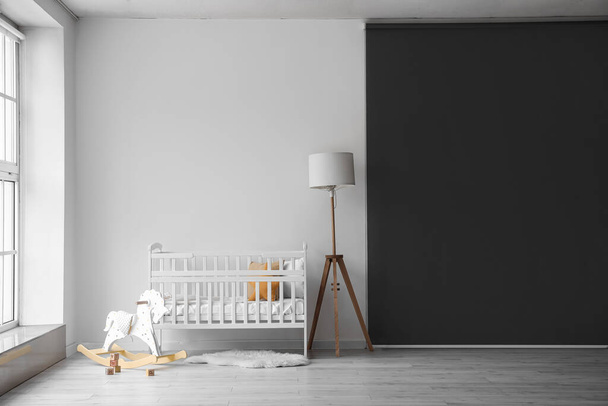 Interior of light nursery with baby crib, lamp and toys - Photo, Image