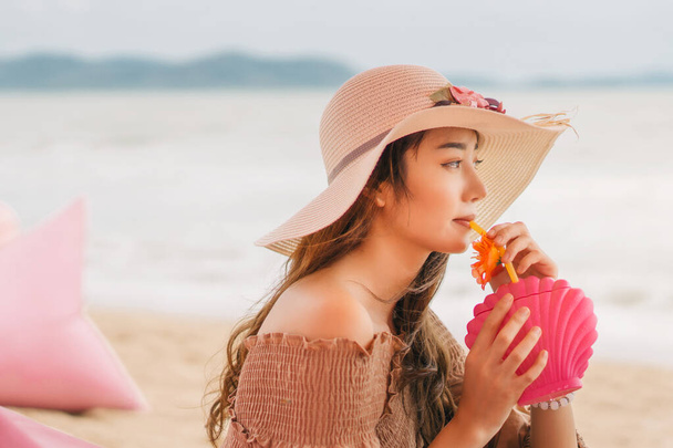 Mladá žena s kloboukem nápoj osvěžující koktejl na pláži kavárna - Fotografie, Obrázek
