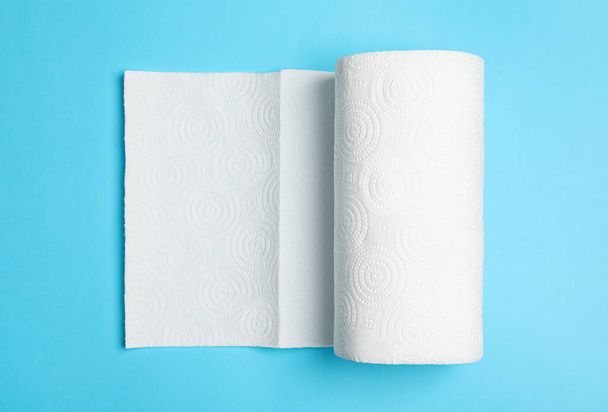 Roll of white paper towels on light blue background, top view - 写真・画像