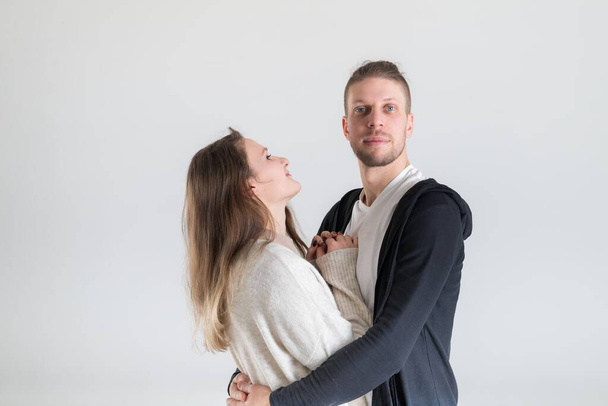 Retrato de um jovem casal europeu abraçando os amantes em um fundo branco. - Foto, Imagem