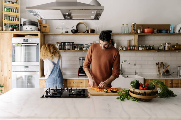 Couple preparing food in kitchen. - 写真・画像
