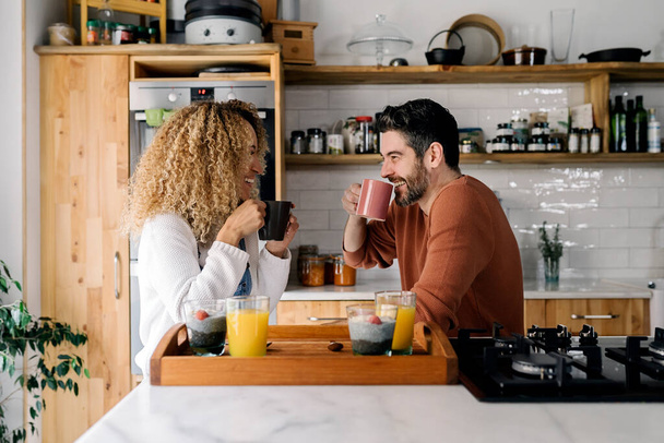 Couple having breakfast in kitchen. - Фото, изображение