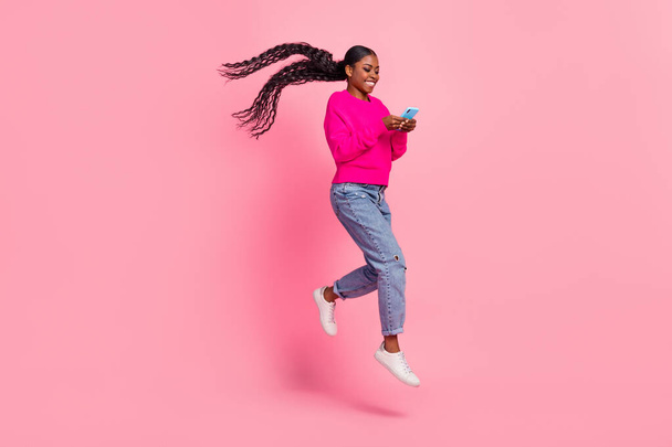 Full body photo of millennial brunette lady look telephone run wear pullover jeans footwear isolated on pink background - Foto, immagini