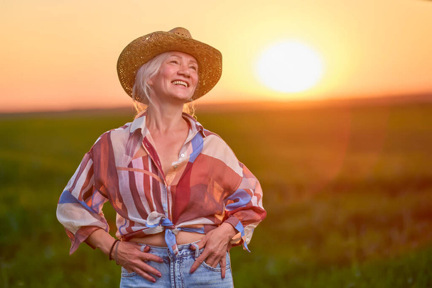 portrait of a middle-aged woman in the wheat field at sunset - Photo, image