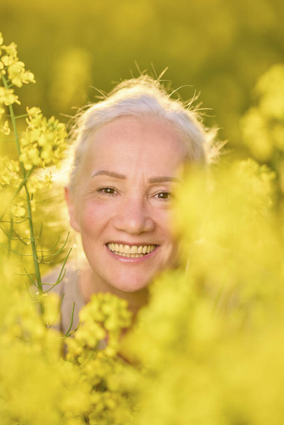Portrait of a middle-aged woman in the rapeseed chain. - Foto, Bild