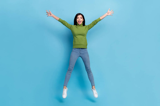 Full length photo of cool millennial brunette lady jump yell wear jumper jeans footwear isolated on blue background - Foto, immagini