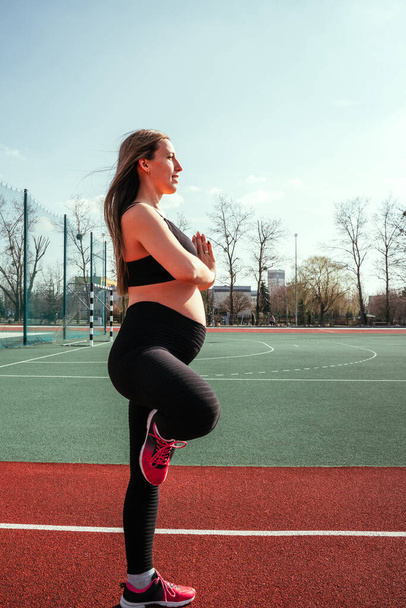 Prenatal gymnastics. Pregnant woman training yoga sport exercise. Prenatal healthy fitness active fit gym outside. Pregnancy fitness - Fotoğraf, Görsel